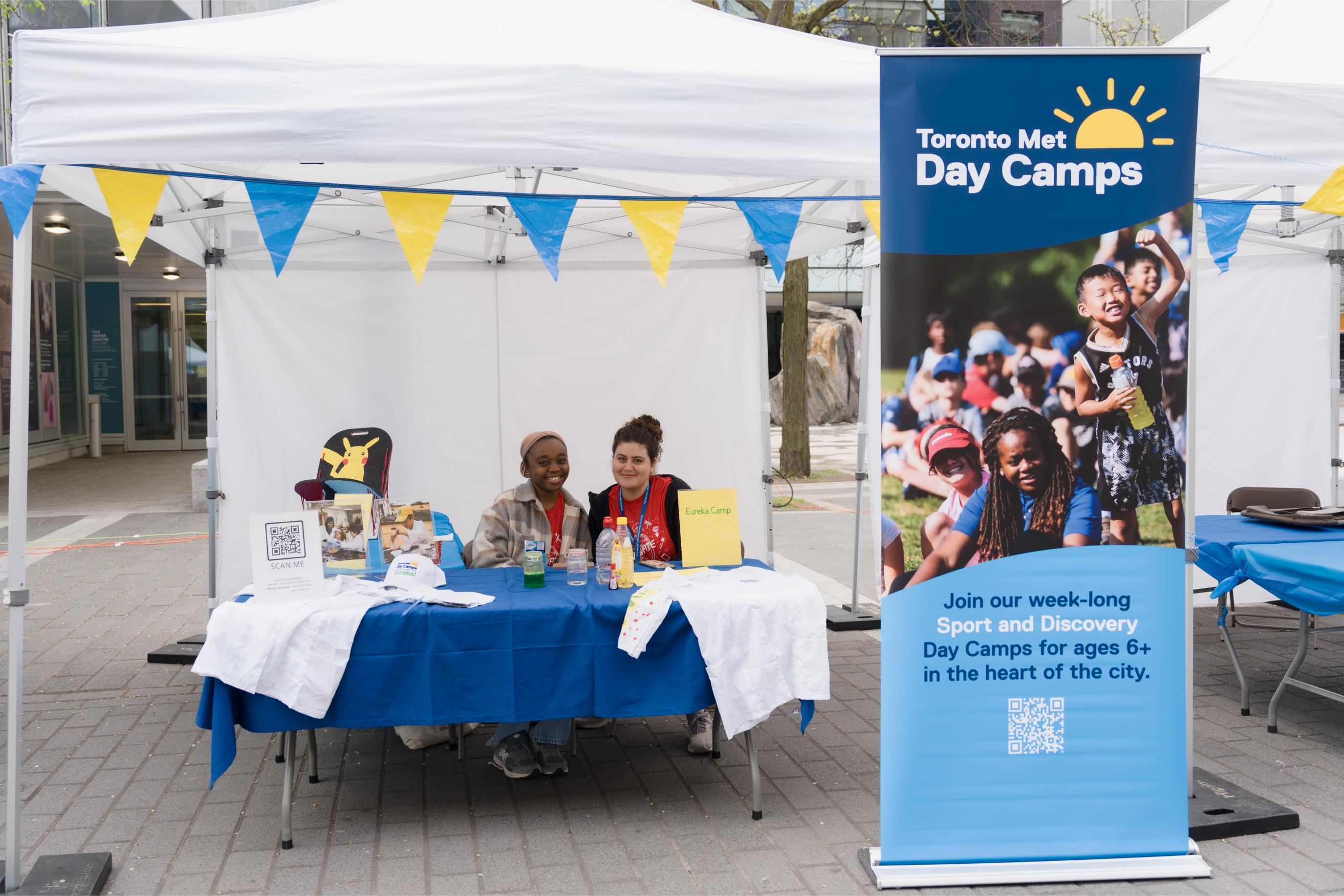 The Toronto Met Day Camp Booth and our volunteers posing at the booth.